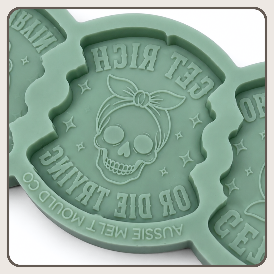 A mint green silicone mold insert featuring an embossed skull wearing a bandana with the text 'GET RICH OR DIE TRYING' and 'AUSSIE MELT MOULD CO' on a white background.
